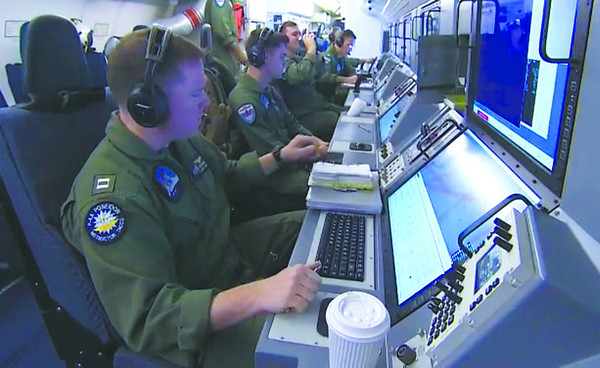 資料圖:美軍技術人員20日在偵察機內搜集南海情報信息。