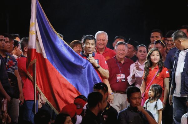 在一次競選活動中,杜特蒂拿著菲律賓國旗 來源:CBS
