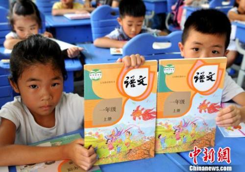 資料圖:一年級新生展示剛領取的語文統編教材 張斌 攝